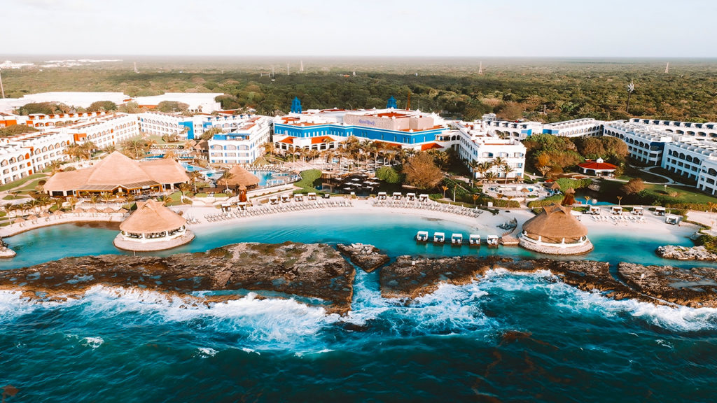 Vista aérea do Hard Rock Hotel Riviera Maya, mostrando a praia privativa, piscinas e a estrutura do resort.