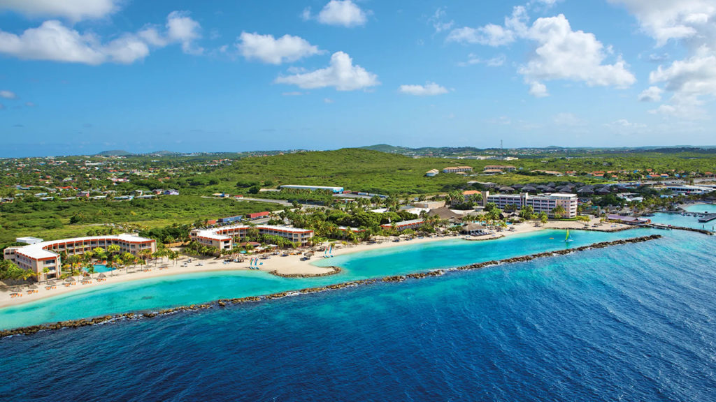 Vista aérea do Sunscape Curaçao Resort Spa & Casino, mostrando a praia, piscinas e a estrutura do resort.